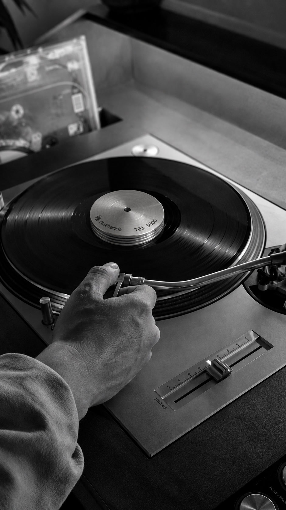 Adjusting the tonearm on a turntable with a realhands weight on the record