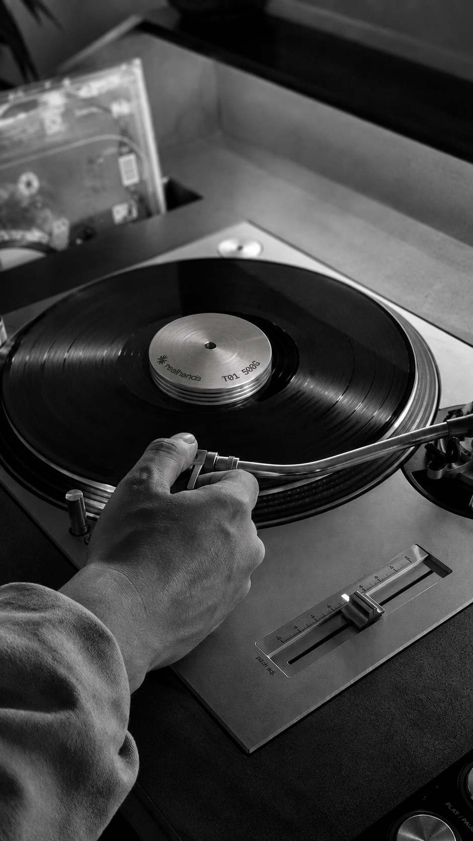 Adjusting the tonearm on a turntable with a realhands weight on the record